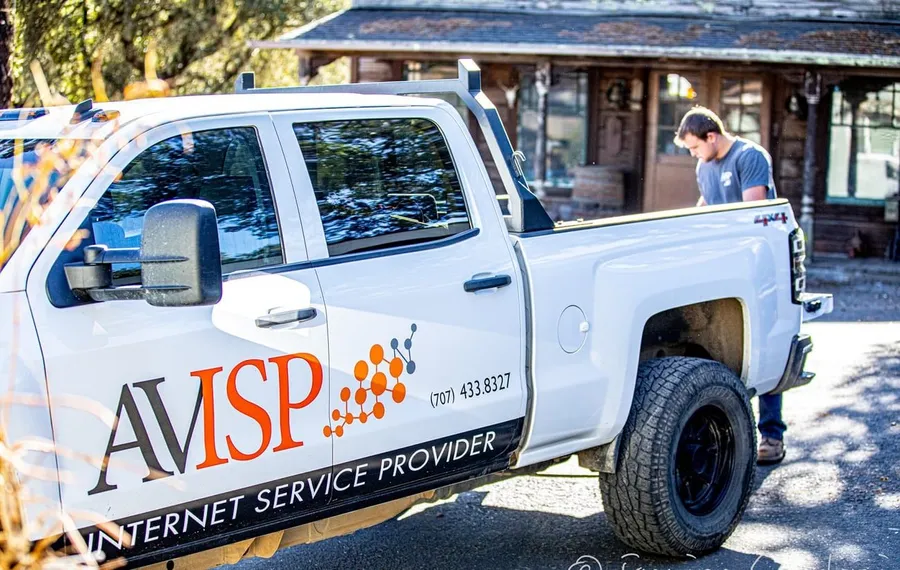 An AVISP technician installing equipment on a rural rooftop.